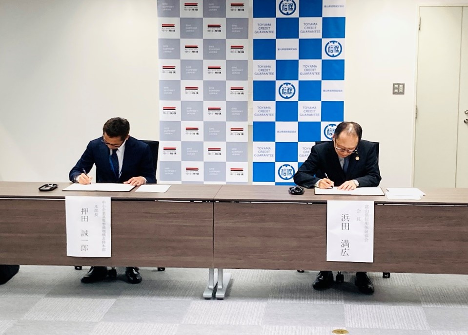 代表者2名が覚書に署名している様子